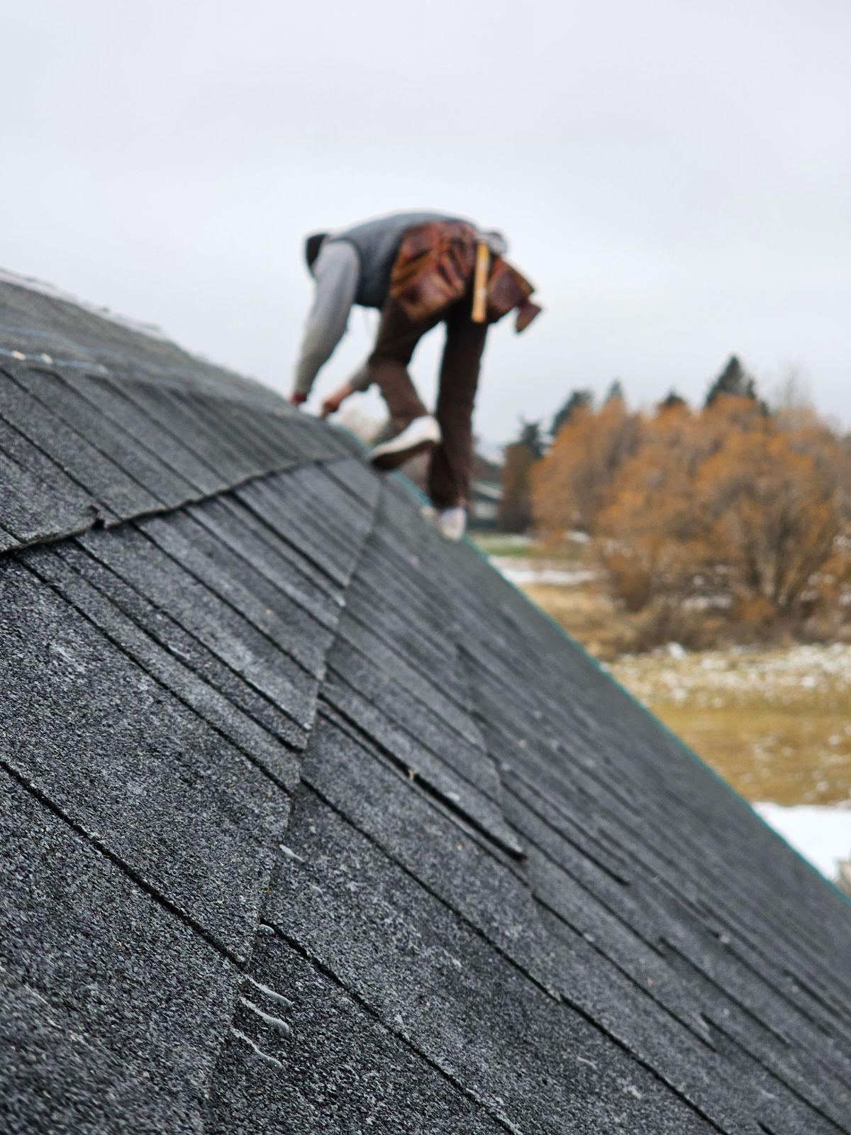 Roofer performing shingle repair work